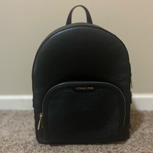 Michael Kors black backpack purse with gold hardware.